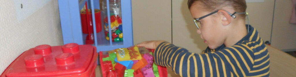 enfant handicape joue avec des briques