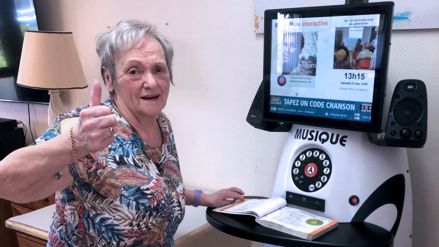 une femme leve le pouce devant la borne interactive melo