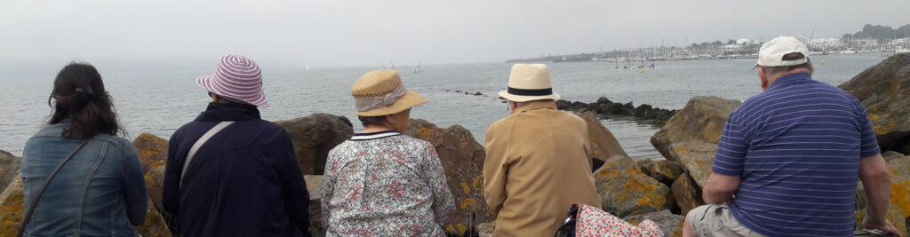 un groupe d'adultes assis face a la mer