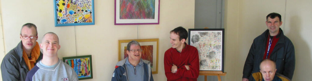 un groupe d'adultes devant des tableaux
