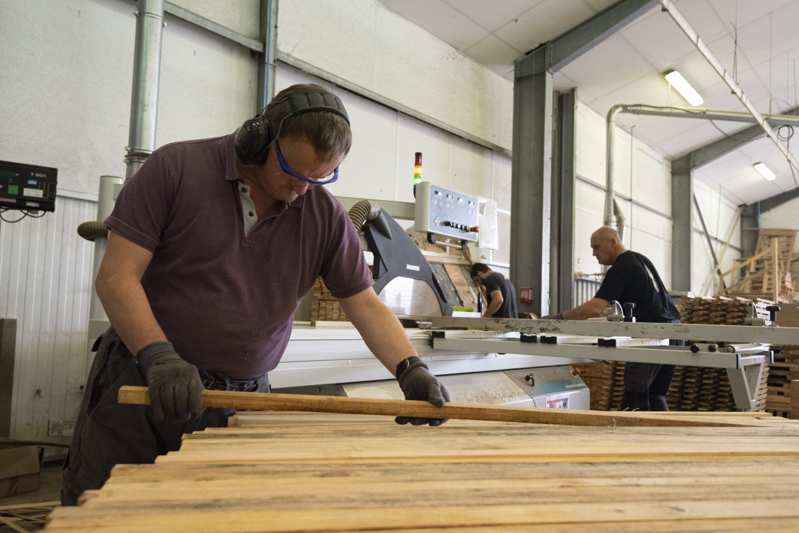 un salarié a l'atelier prepare des planches de bois