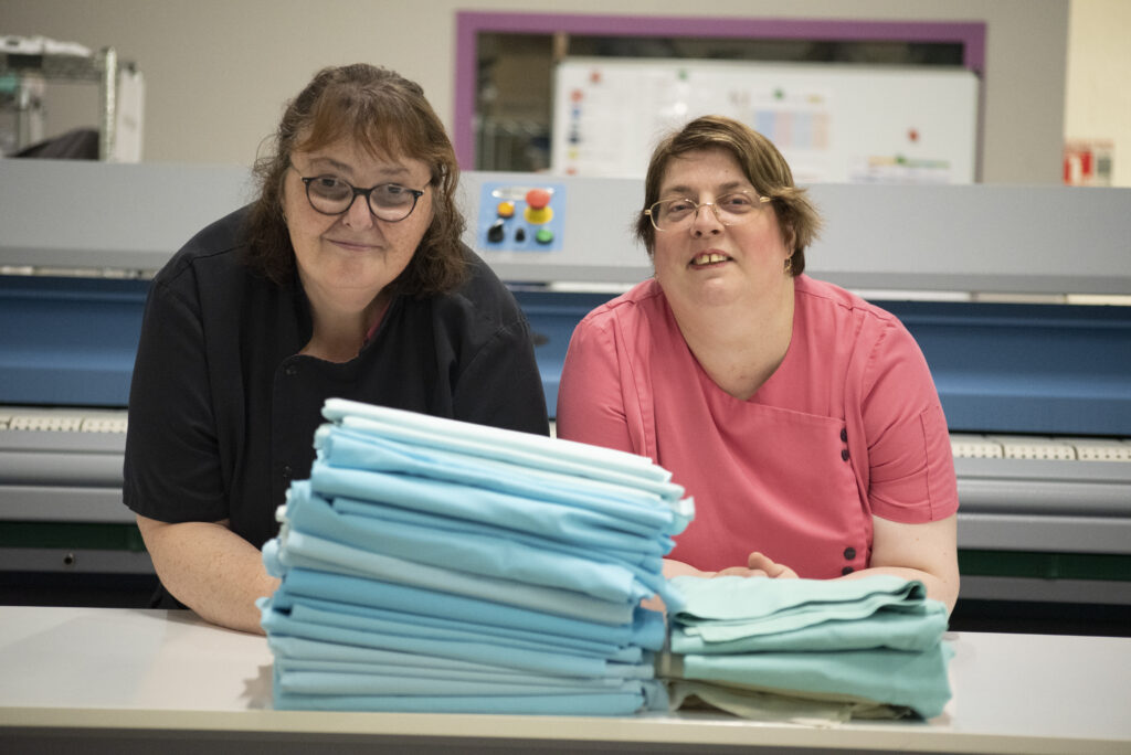deux salariees de la blanchisseries devant du linge plie