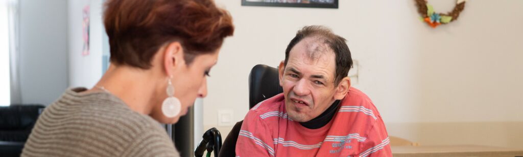 une soignante avec une personne en fauteuil roulant
