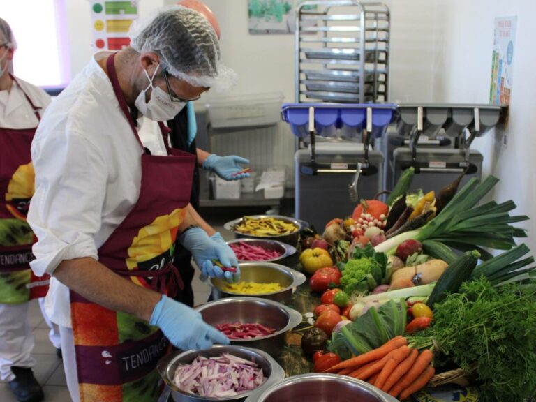 trois personnes travaillent en cuisine collective