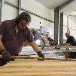 un salarié a l'atelier prepare des planches de bois